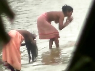 Indian women bathing hard by the geyser